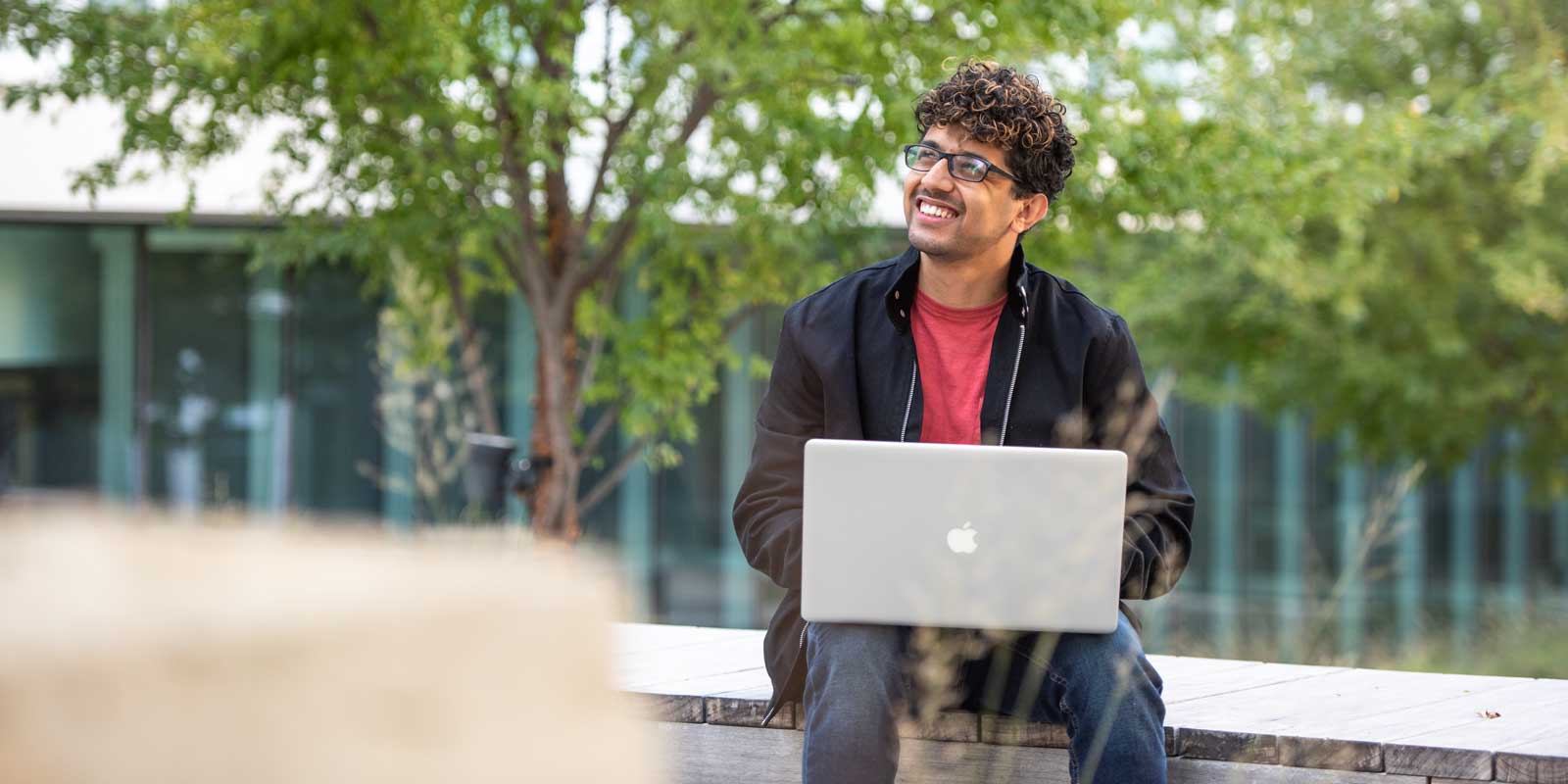 Student works on laptop outside.