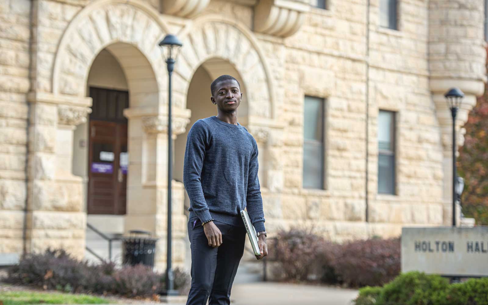 Student in front of Holton Hall. 