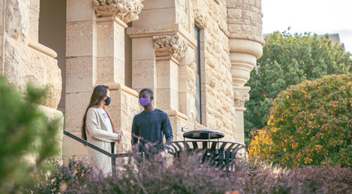 Students wearing face coverings outside Holton Hall.