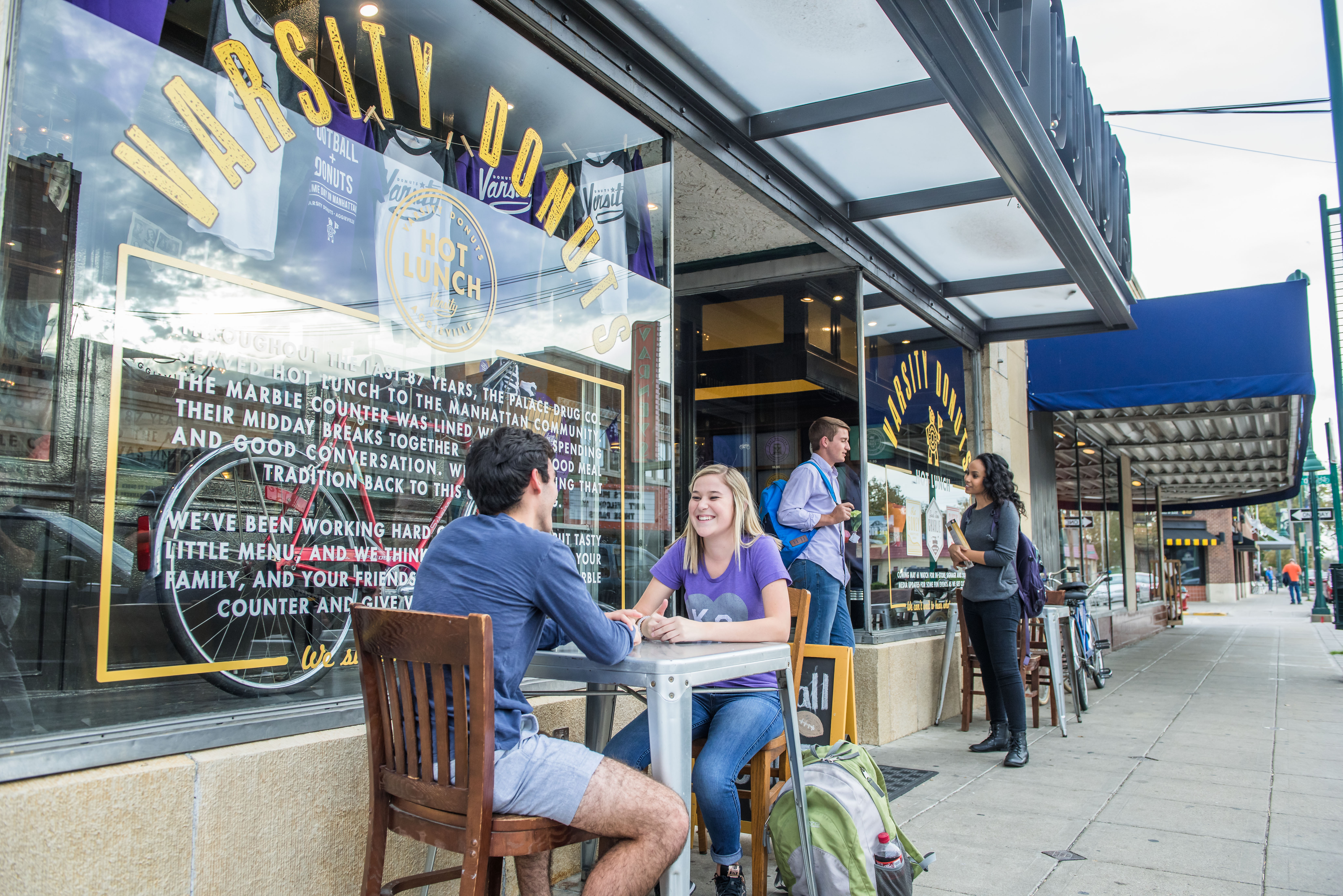 Students sitting outside Varsity Donuts in the Aggieville Business District