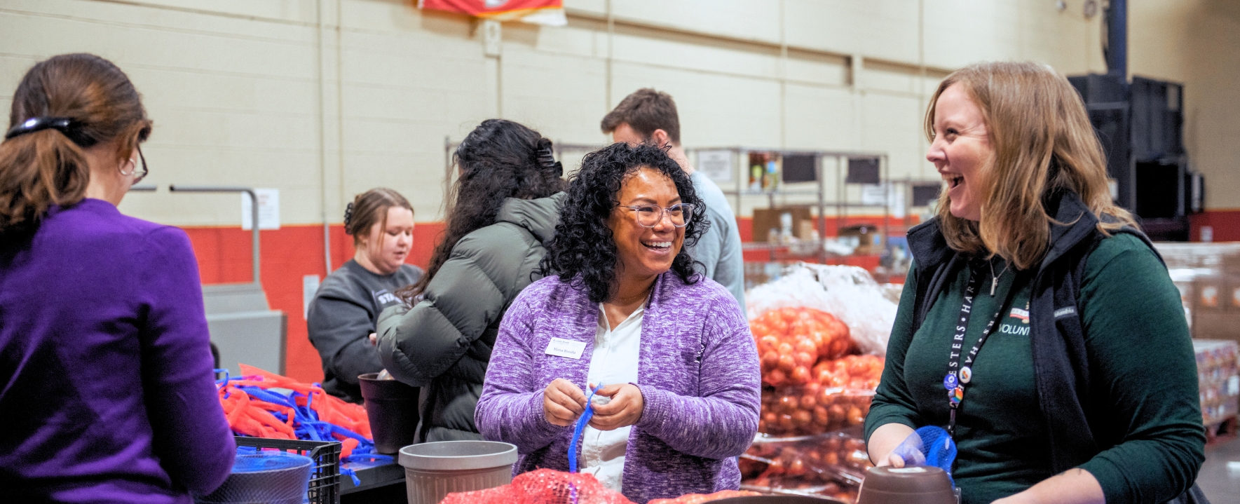 Woman laughing while packing onions for a food service project