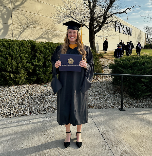 Sophia Cori poses with her diploma in cap and gown.