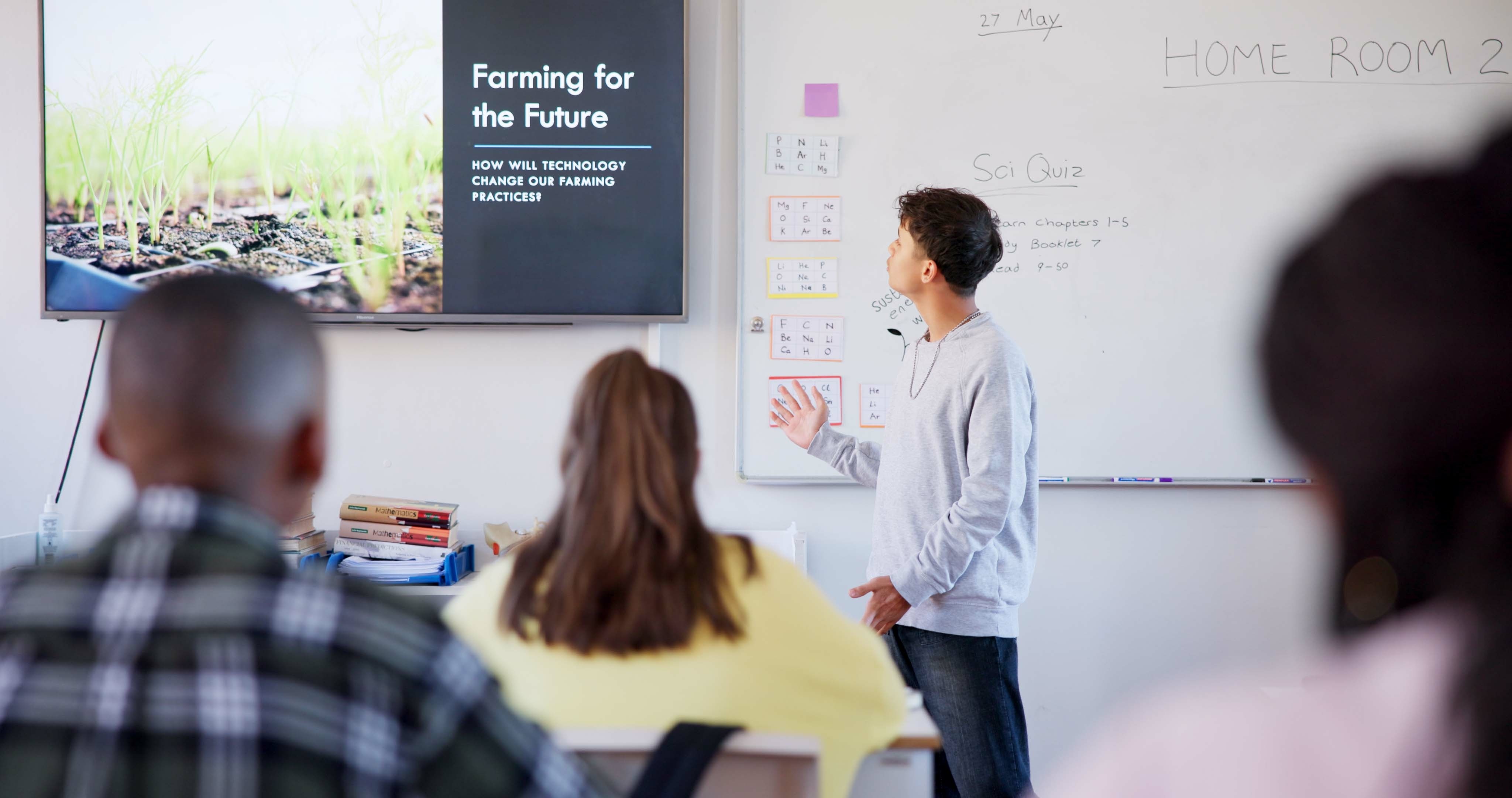 A student standing in front of a classroom to present