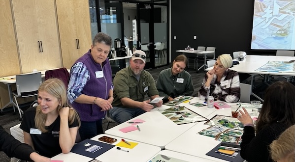 workshop participants play the Watershed Game around a table