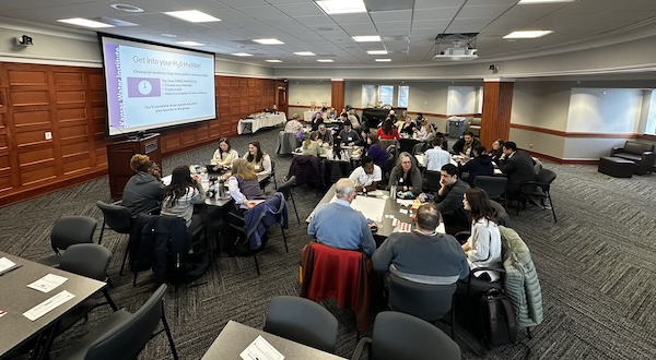 groups of participants sit at discussion tables