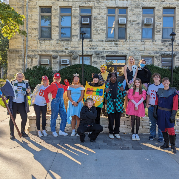 A group of students in front of a building dressed up in various cosplay