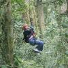 1 student zip-lining through the forest.