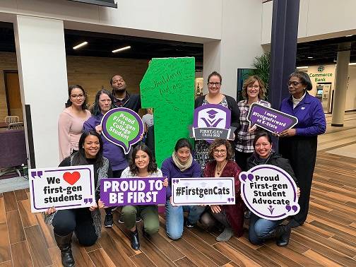 Group of students and faculty with "Proud to be First" signs.