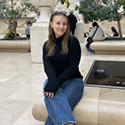Jaidyn sits on the edge of a public foundation in France.