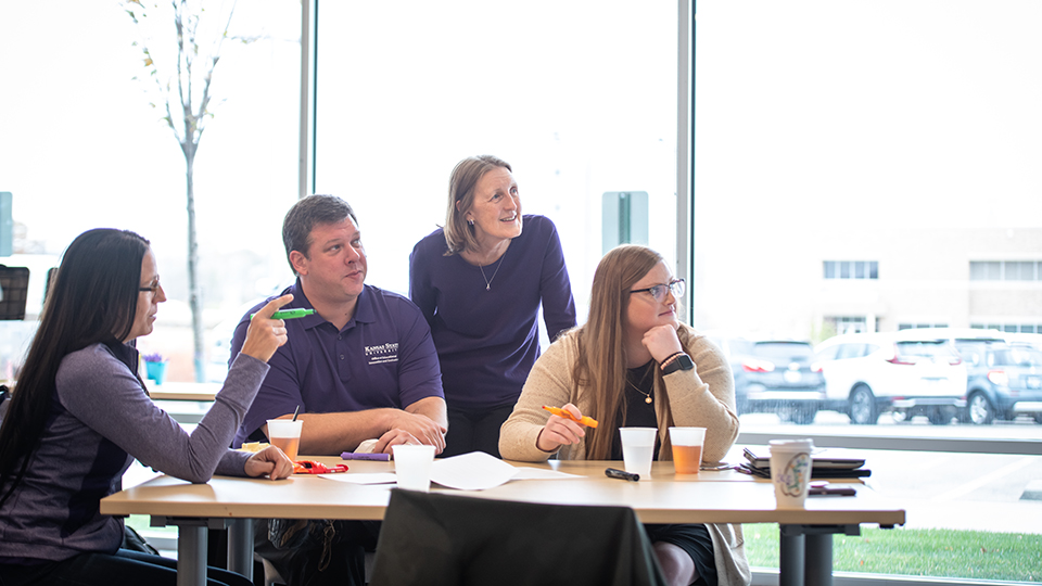 A group seated around a table looking off screen