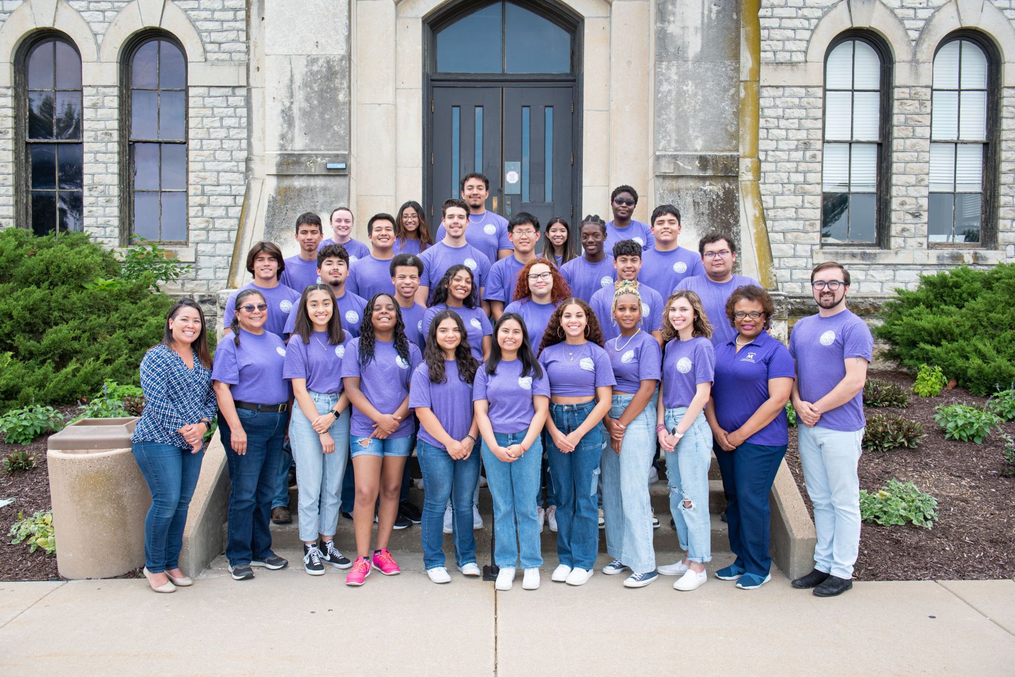 group of people wearing matching purple shirts in front of Anderson Hall