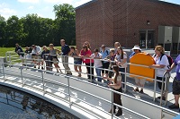 K-State engineering grad Heather Phillips leads a tour of the Olathe Cedar Creek Wastewater Treatment Plant for Kansas teachers learning about urban water and human and animal health.