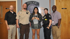 K-State Police Glen Brown, Randy Myles, Samantha Purdy and Jason Blackburn present April Aranda with gift cards.