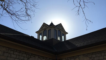 A clear and sunny sky behind the cupola on Holtz Hall. 