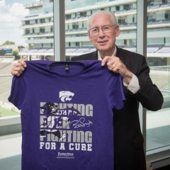 Coach Snyder holding 2018 Fighting for a Cure shirt