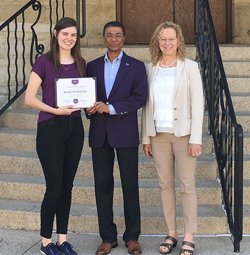 Madelyn Pospisil receives the Sullivan Poetry Award from Dean Amit Chakrabarti and Assistant Dean Alison Wheatley.