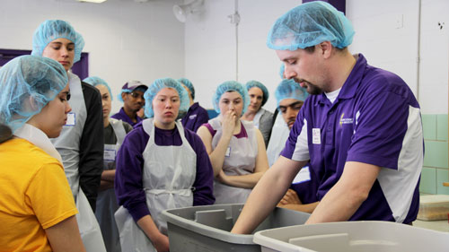 Jason Watt, Buhler Instructor of Milling, demonstrates to the prospective students how to create a “Wet Slick”. This hands-on activity is used to show differences in quality of different types of flour. 