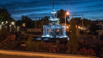 A fountain at the Kansas State University Gardens glows at night.