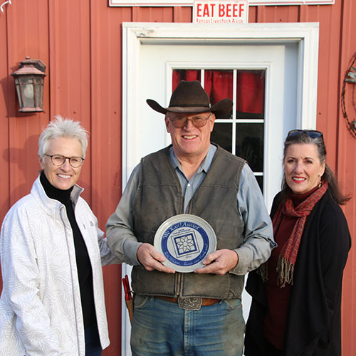 Ron WIison (center) receives the We Kan! award from representatives of the Kansas Sampler Foundation.