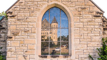 Fairchild Hall's reflection in Danforth Chapel window