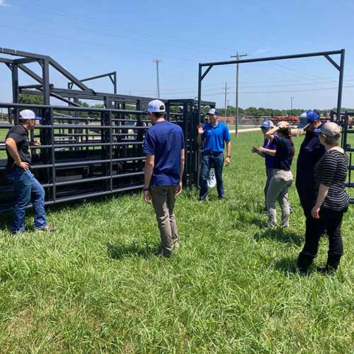 Rawhide sales representative Eric Blythe helps the livestock services team at K-State set up a portable corral.