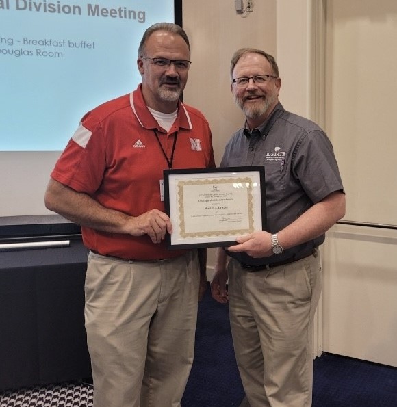 Dr. Marty Draper, right, receives his Distinguished Service Award from North Central APS Division President Loren Giesler