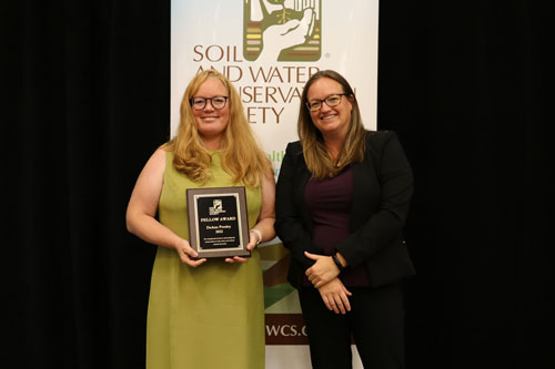 Dr. DeAnn Presley, professor of agronomy (left) is presented the Fellow Award by Clair Lindahl (right), CEO of the Soil and Water Conservation Society.