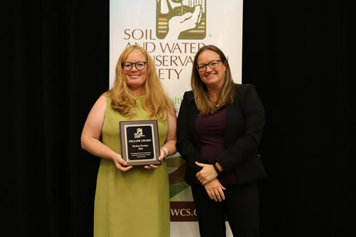 DeAnn Presley (left), professor of soil science, is presented the Fellow Award from Clare Lindahl (right), CEO of the Soil and Water Conservation Society.