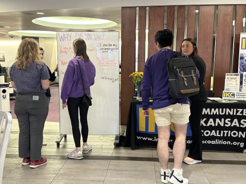 Sakshi Bhati, project lead, and Johnna Tumberger, Strategic Communication intern, speak with other K-State students at the "Why I Vax" table event in the K-State Union.