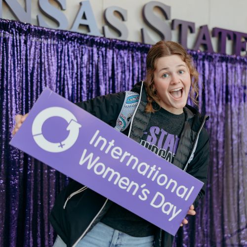 Student Holding IWD Sign
