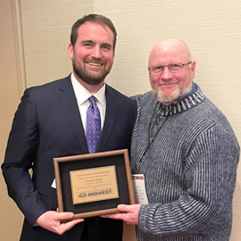 Jon Bergstrom, senior technical support manager, swine, at DSM Nutritional Products presents the Outstanding Young Researcher Award to Chad Paulk on March 14.