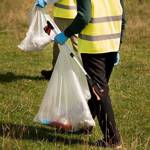 Two people participating in litter pickup