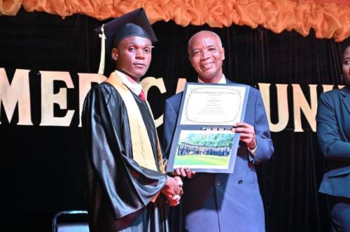 Mr. Walmy Borgard receiving his diploma from President Dr. Paul Touloute of AUC at the graduation. 