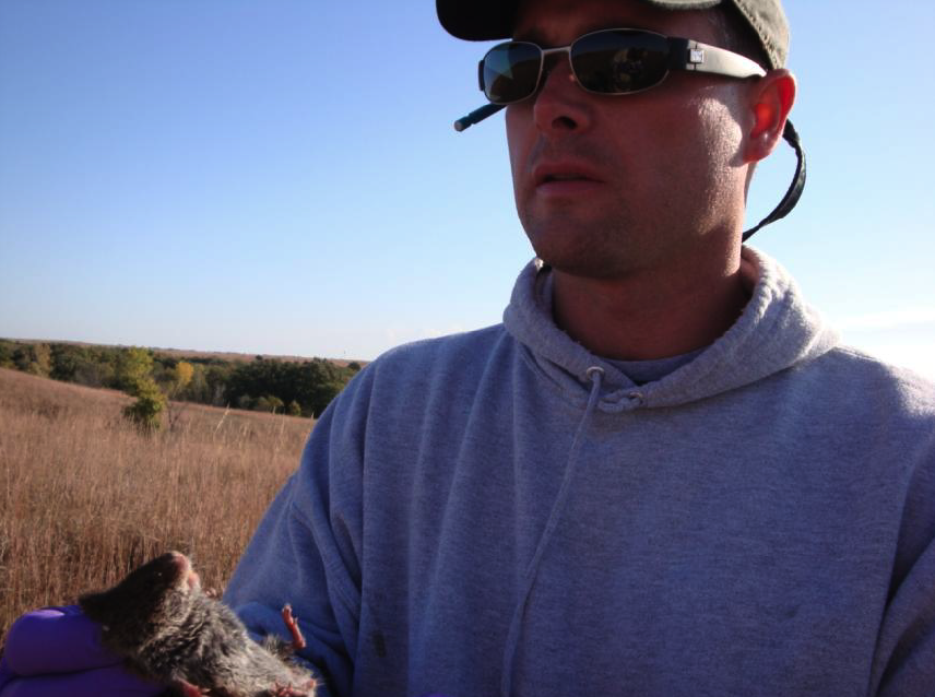 Derek Moon with a prairie vole at one of his study sites at Fort Riley, Kansas.