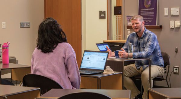 Instructor talking with student in classroom