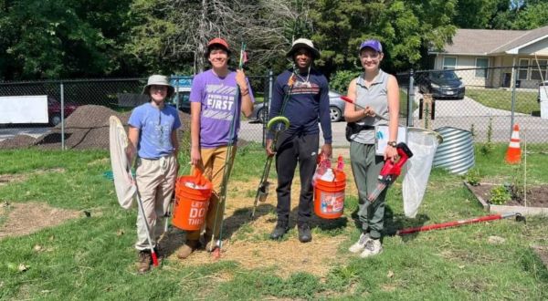 Students at a community clean-up event hold yard tools and buckets