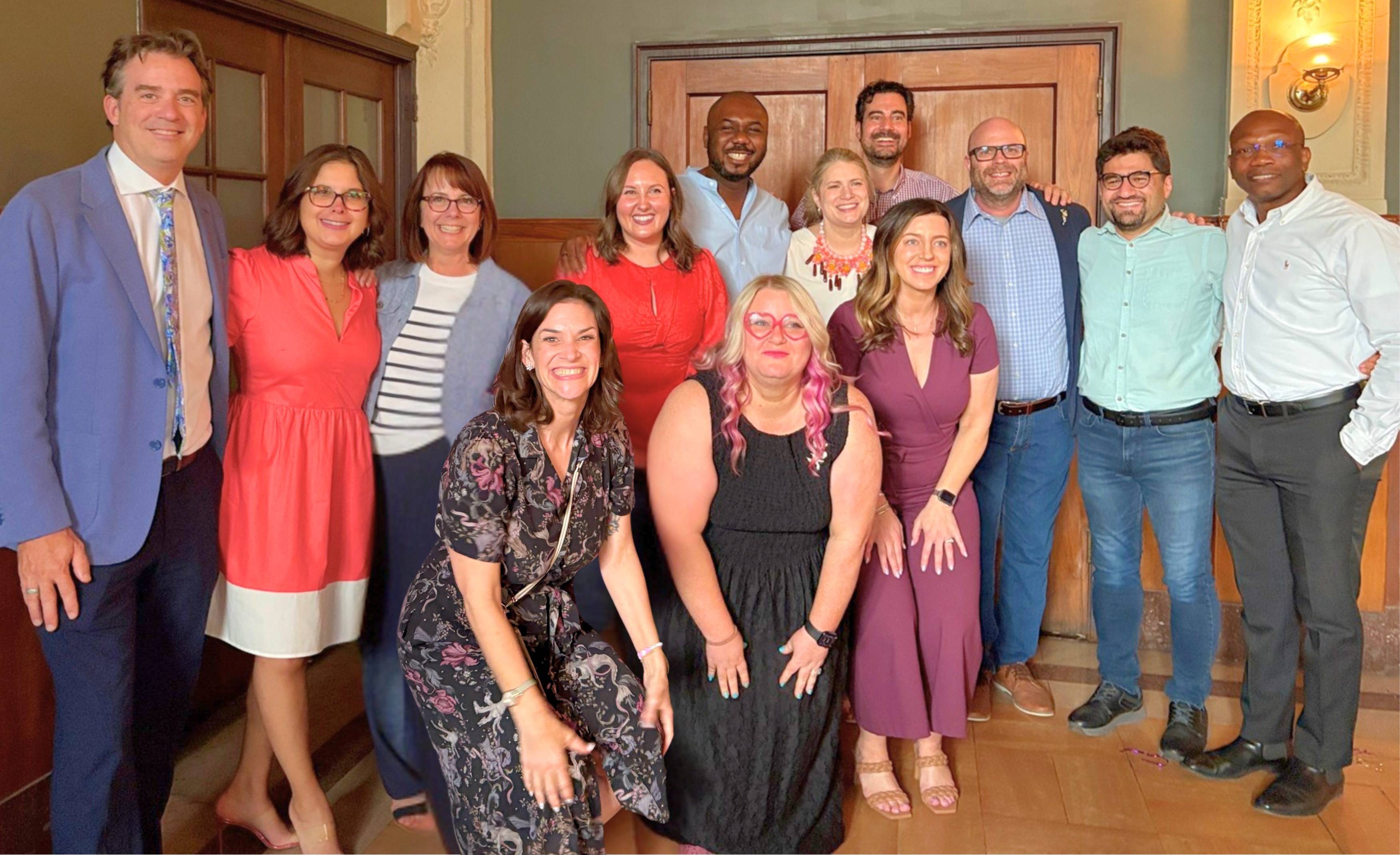 Graduates, faculty, and advisors pose for photo at graduation reception