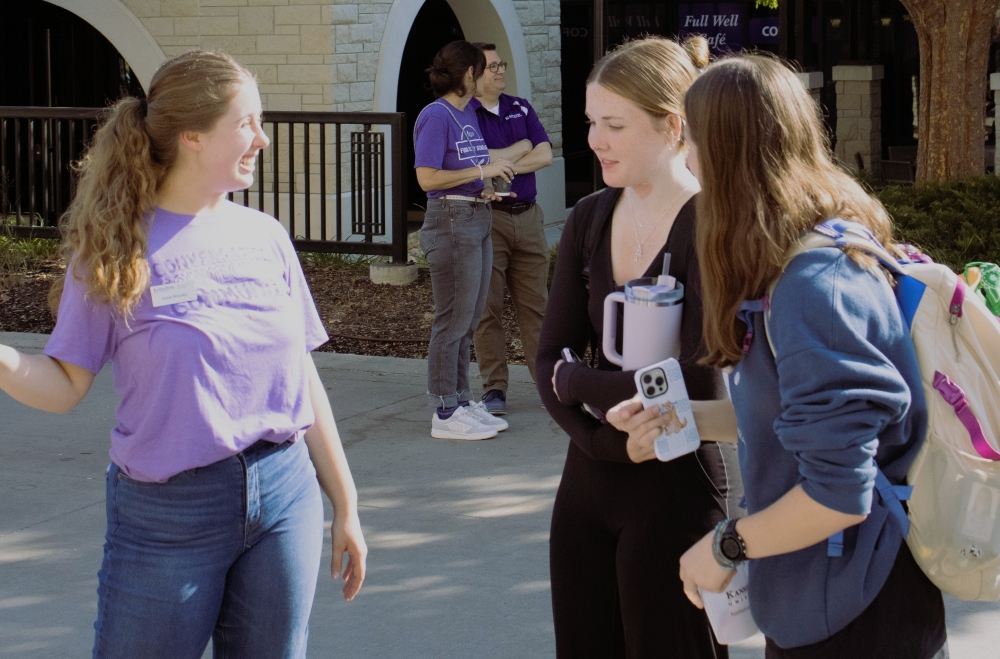 Josie talks with students at a table event