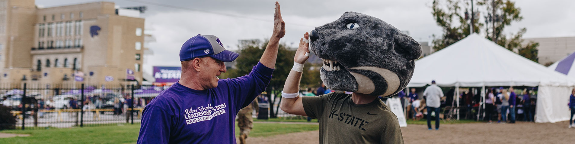 Faculty high fives Willie the Wildcat