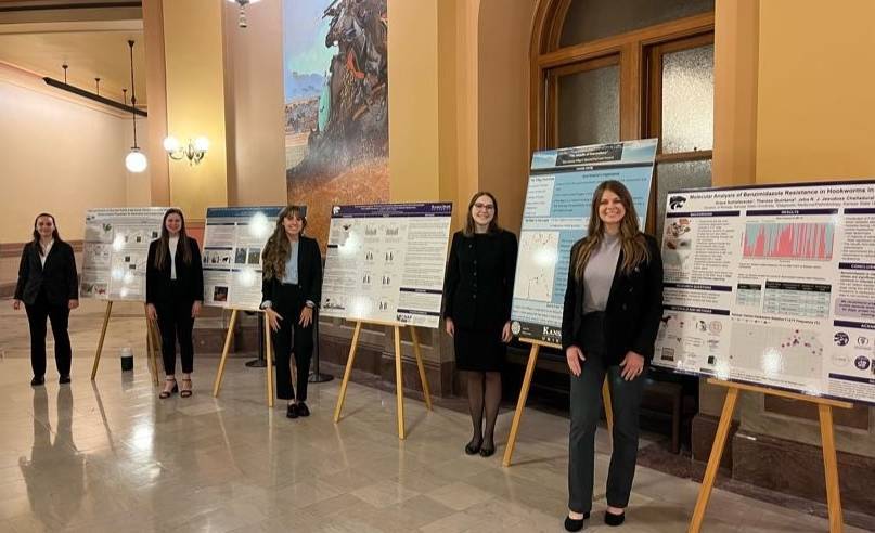 Students presenting their research with poster boards