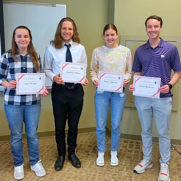 Four students pose with award certificates