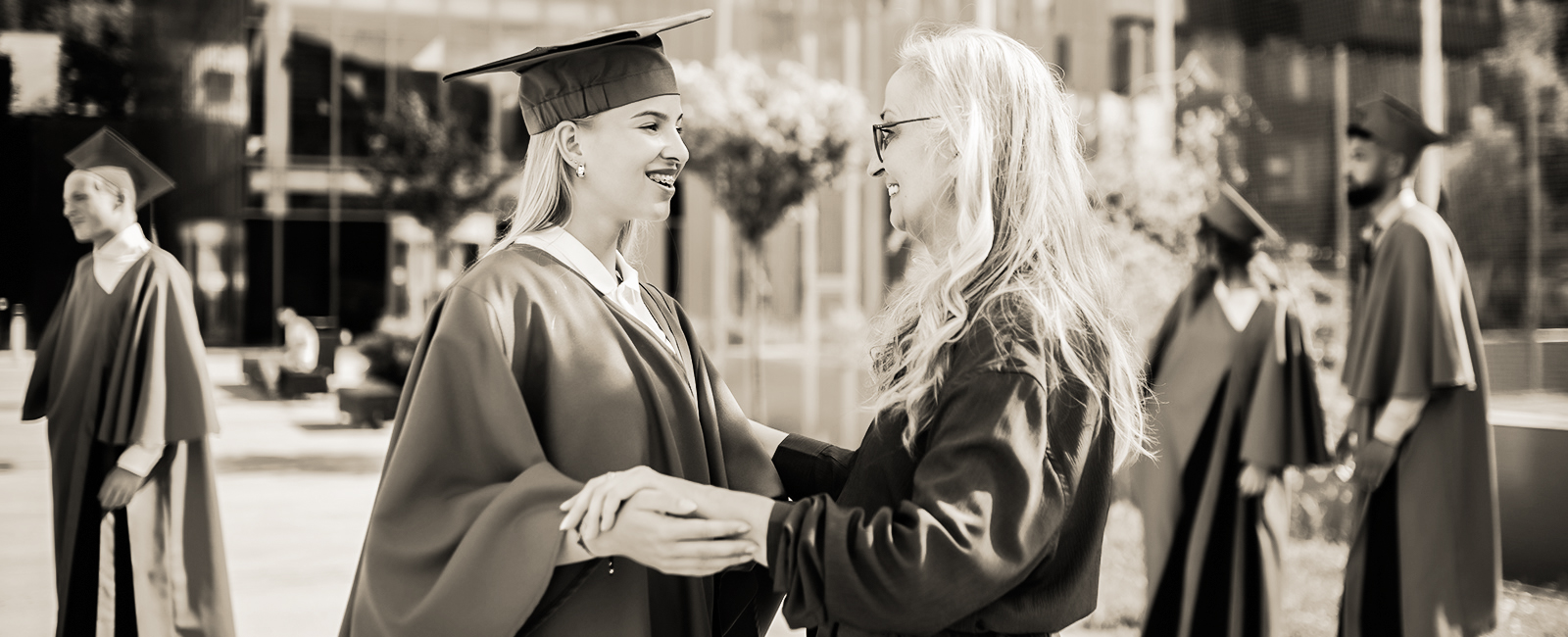 female graduate talking to a family member outside