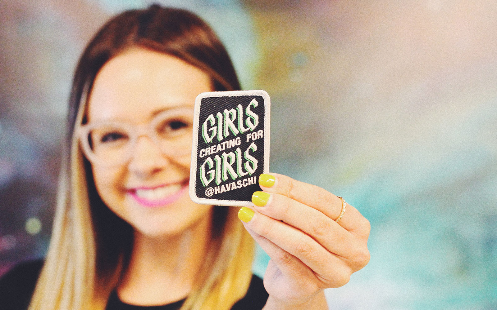 student holding up a promotional patch she worked on for an internship