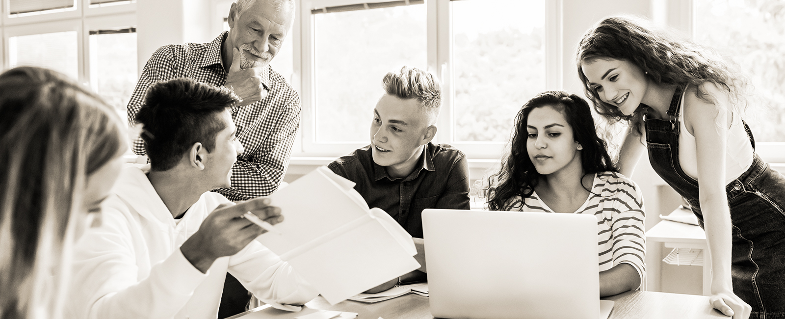 students working on project in large group at table with professor