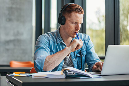 male student studying with headphones on