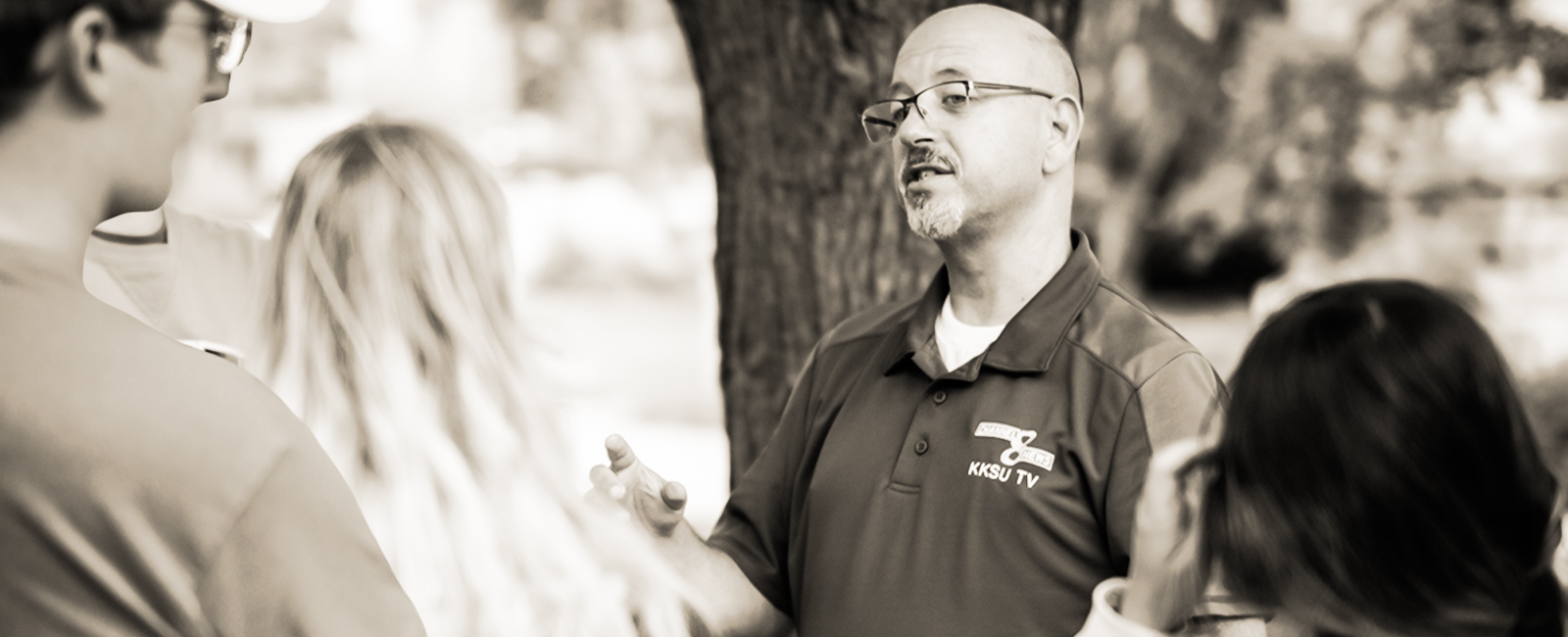 faculty member talking with students outside