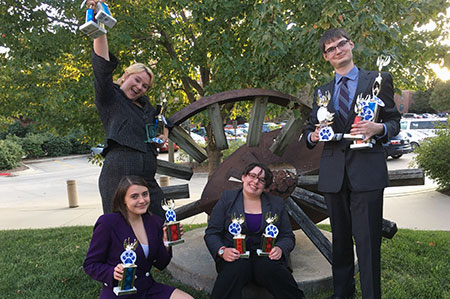 Forensics students holding trophies outside