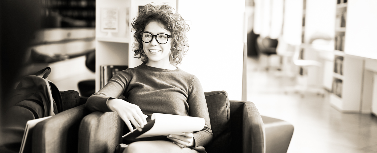 smiling graduate student in wingback chair