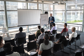 male presenting to a room of business colleagues