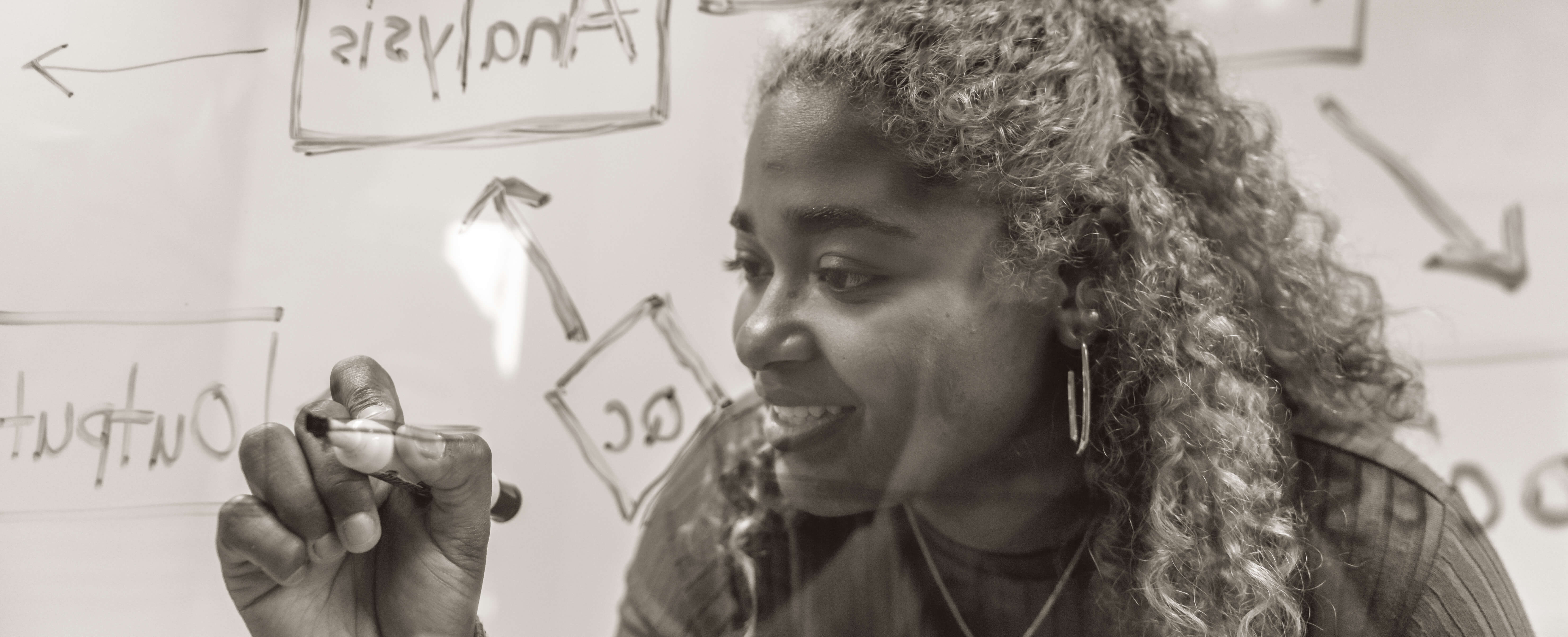 female student writing on board